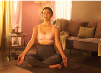 A confident woman wearing a soft-cup bra, smiling in natural light.